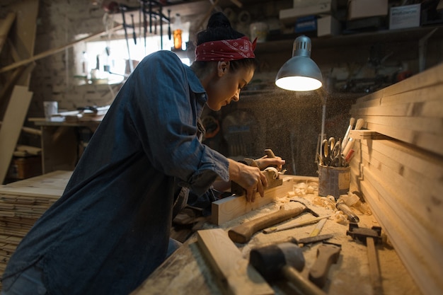 La donna artigiano lavora in un laboratorio di legno. Concetto fatto a mano