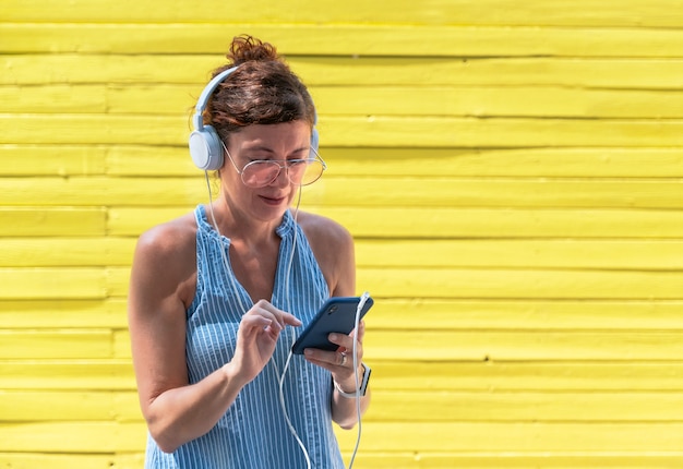 La donna ascolta la musica con le cuffie e lo smartphone