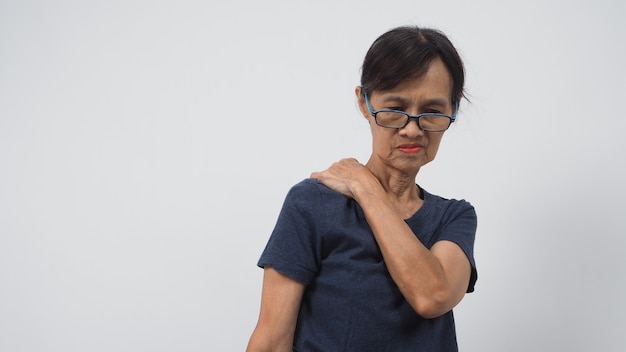 La donna asiatica anziana o più anziana ha avuto una postura di mal di schiena su sfondo bianco.