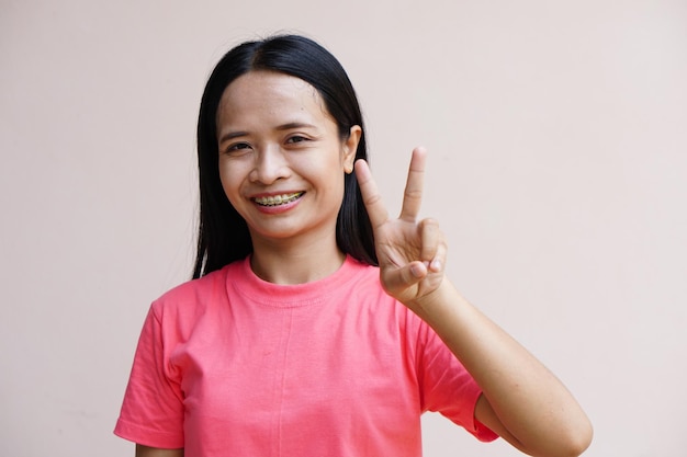 La donna asiatica che regge due dita significa lotta
