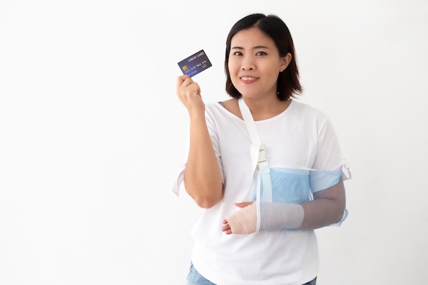 La donna asiatica che tiene la carta di credito e ha messo su una stecca morbida