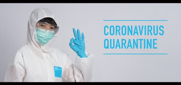 La donna asiatica del medico indossa tuta DPI o dispositivi di protezione individuale e maschera e guanti medici
