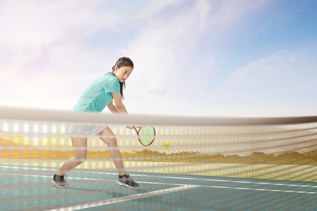 La donna asiatica del tennis con una racchetta di tennis in sue mani ha colpito la palla