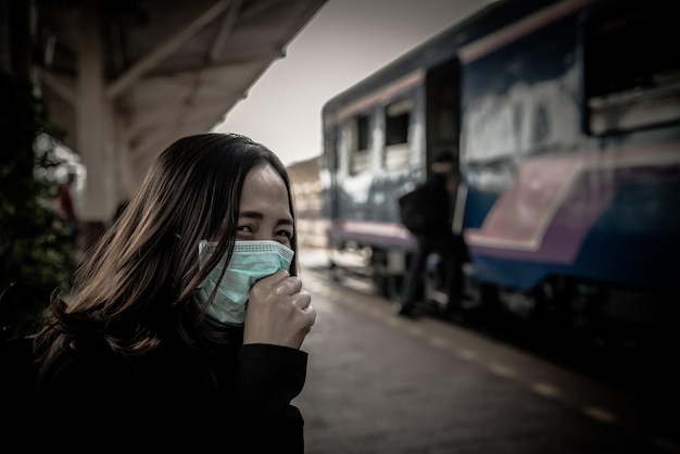 La donna asiatica del viaggiatore indossa la maschera per proteggere il coronavirusLa donna tailandese che indossa la maschera facciale protegge le vie respiratorie e filtra il particolato PM25