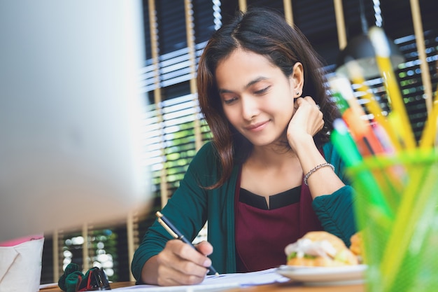 La donna asiatica gode con il suo lavoro