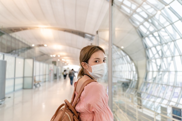 La donna asiatica indossa maschere mentre viaggia al terminal dell'aeroporto. Nuovo concetto di prevenzione delle malattie normale, covid19.