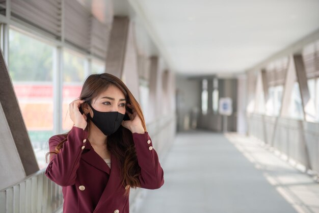 La donna asiatica indossa una maschera facciale per proteggere il virus COVID19La gente della Thailandia La mancanza di respiro della giovane donna Problema di respirazione della tosse del coronavirus