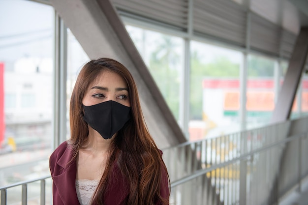 La donna asiatica indossa una maschera facciale per proteggere il virus COVID19La gente della Thailandia La mancanza di respiro della giovane donna Problema di respirazione della tosse del coronavirus