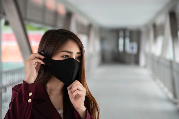 La donna asiatica indossa una maschera facciale per proteggere il virus COVID19La gente della Thailandia La mancanza di respiro della giovane donna Problema di respirazione della tosse del coronavirus