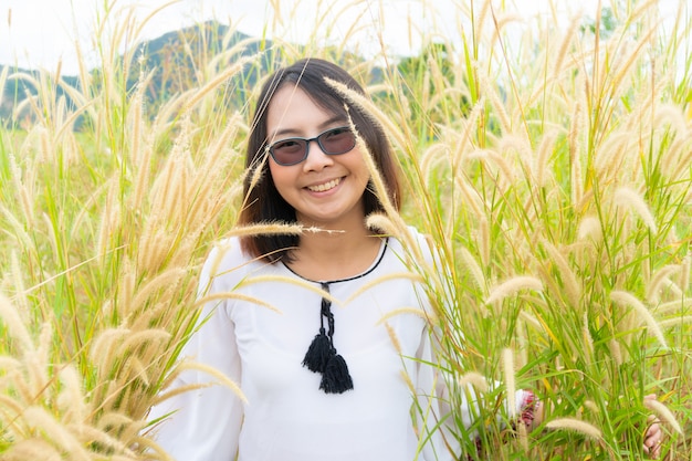 La donna asiatica si distende nel campo di erba.