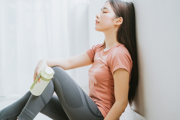 La donna asiatica sta riposando dopo lo yoga