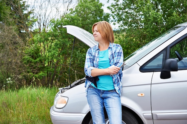 La donna attende aiuto vicino all'auto rotta