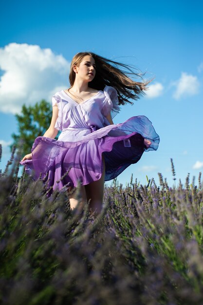 La donna attraente sul campo di lavanda si diverte