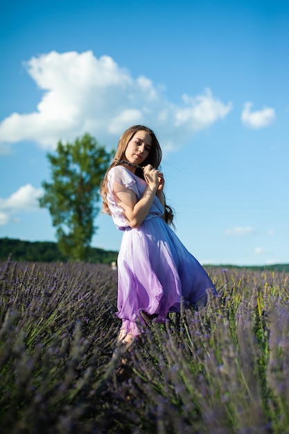 La donna attraente sul campo di lavanda si diverte