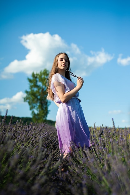 La donna attraente sul campo di lavanda si diverte