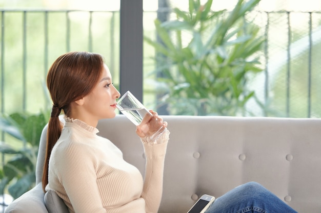 La donna beve acqua e si sente felicemente a casa