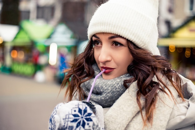 La donna beve caffè caldo alla fiera invernale