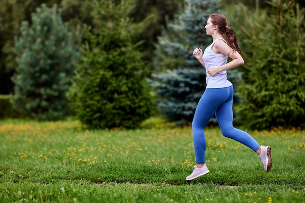 La donna bianca si sta allenando nel parco in leggins