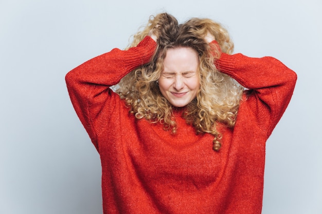 La donna bionda frustrata stressante si strappa i capelli, si rammarica di aver sbagliato