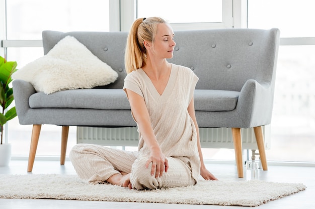 La donna bionda si voltò di lato e allungò la schiena durante lo yoga mattutino