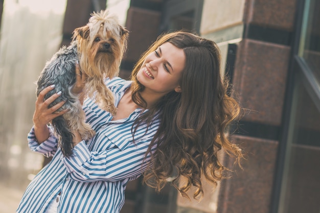 la donna cammina con un cane nella via della città.