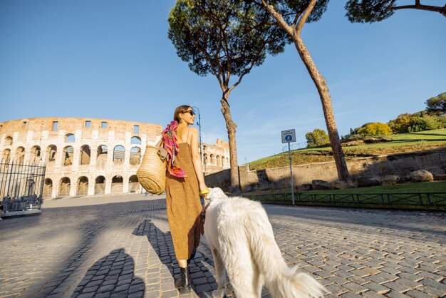 La donna cammina con un cane vicino al Colosseo a Roma