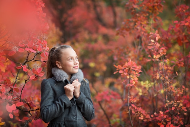 la donna cammina nel fogliame di rad luminoso del parco di autunno