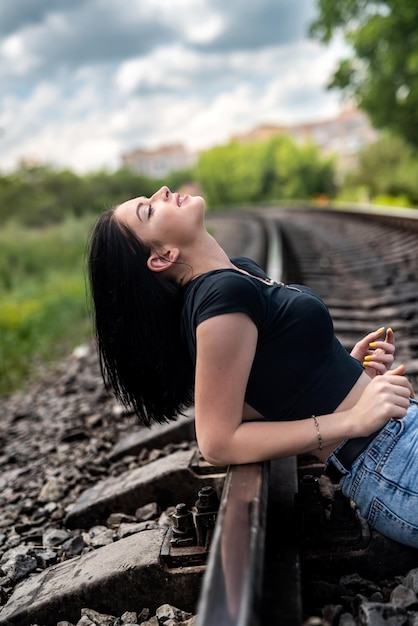 La donna cammina sui binari della ferrovia, viaggio di stile di vita estivo