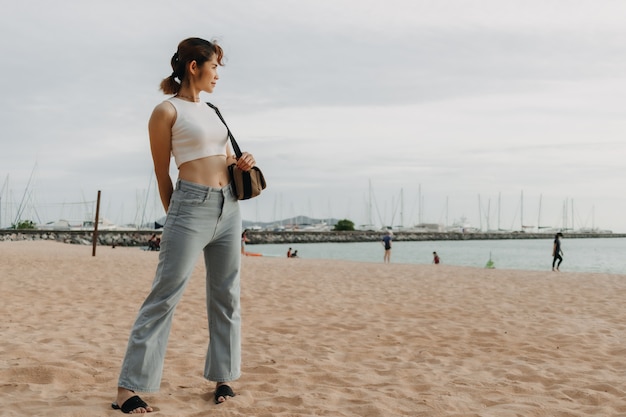 La donna cammina sulla spiaggia in estate il concetto di vacanza estiva