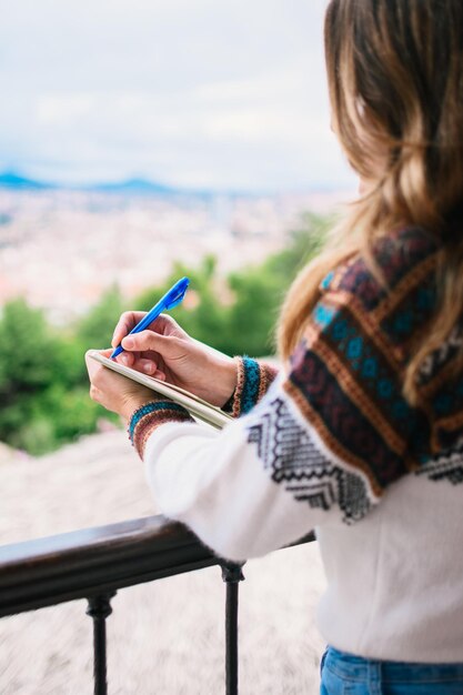 La donna caucasica si è concentrata e scrive con una penna in un taccuino