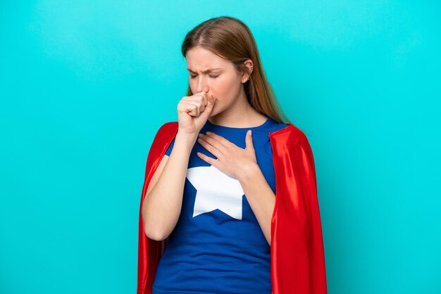 La donna caucasica super eroe isolata su sfondo blu soffre di tosse e si sente male