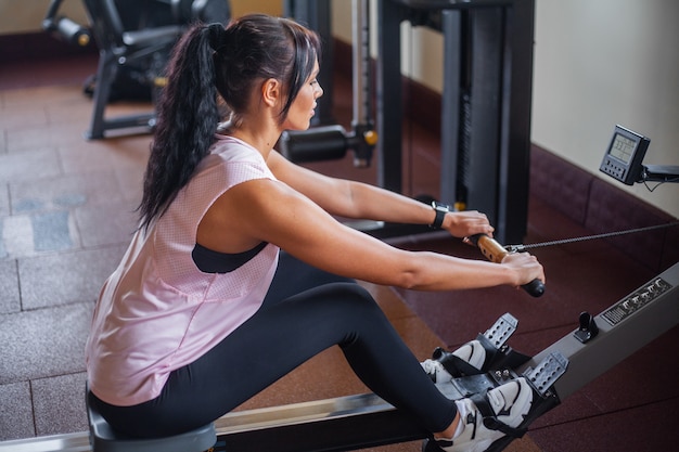 La donna che fa gli addominali si esercita in una palestra di forma fisica