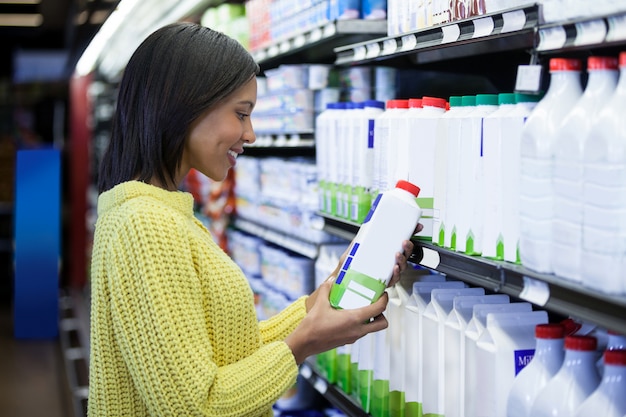 La donna che guarda il latte imbottiglia la sezione della latteria