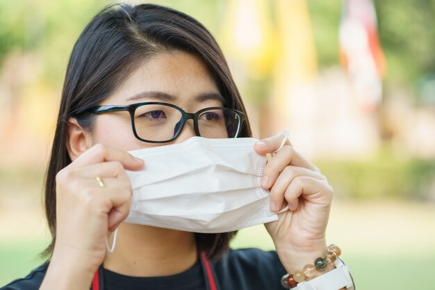 La donna che indossa la maschera protettiva protegge il filtro dall'inquinamento atmosferico (PM2.5) o indossa la maschera N95