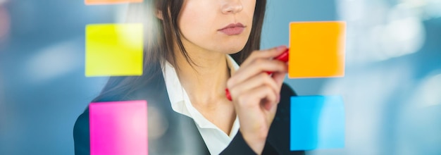 La donna che scrive una nota sull'adesivo