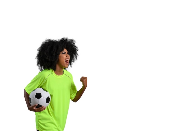 La donna che tiene il pallone da calcio grida celebrando con i grandi capelli afro della mano chiusa che fioriscono verde