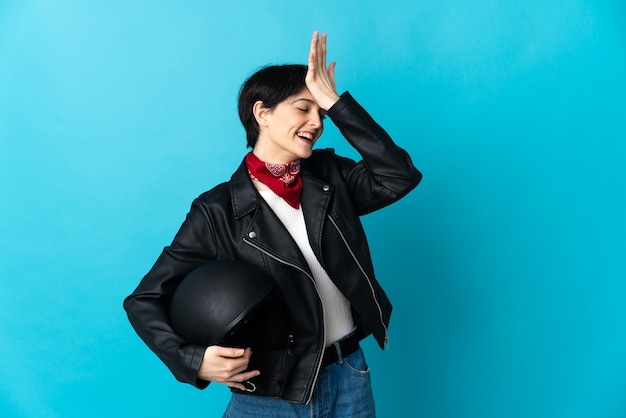 La donna che tiene un casco da motociclista isolato su uno spazio blu ha realizzato qualcosa e intende la soluzione