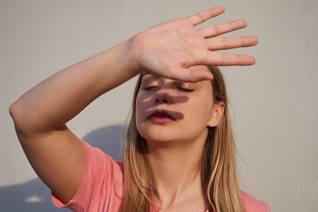 La donna chiude la mano dalla luce solare intensa un'ombra sul viso Il concetto di depressione della salute mentale di conflitto