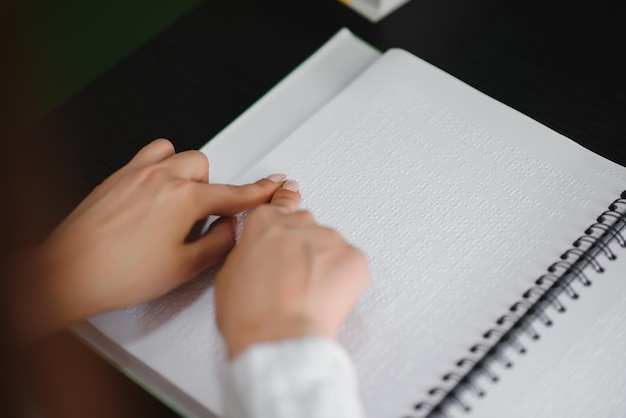 La donna cieca legge il libro scritto in Braille Chiudere il tocco del dito sul codice braille