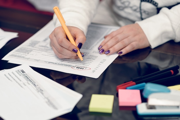 La donna compila il modulo fiscale lavorando con documenti fiscaliModulo di dichiarazione dei redditi individuale 1040