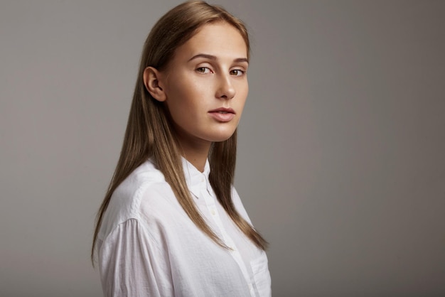 La donna con i capelli lisci indossa una camicia bianca