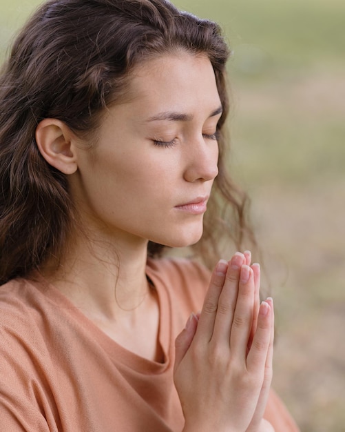 La donna con i capelli ricci medita in un parco yoga e meditazione per la salute mentale e fisica