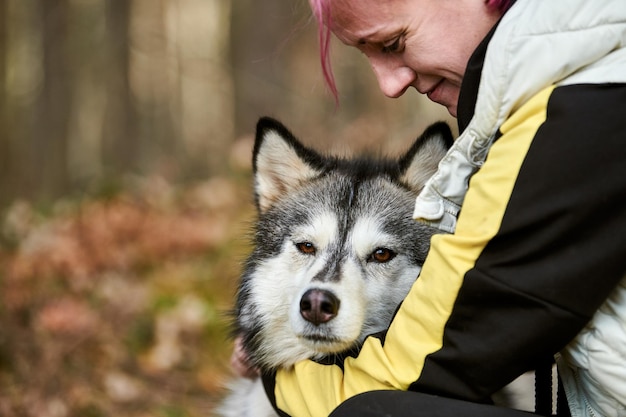 La donna con i capelli rosa abbraccia l'amato cane Siberian Husky, il vero amore per l'uomo e l'animale domestico