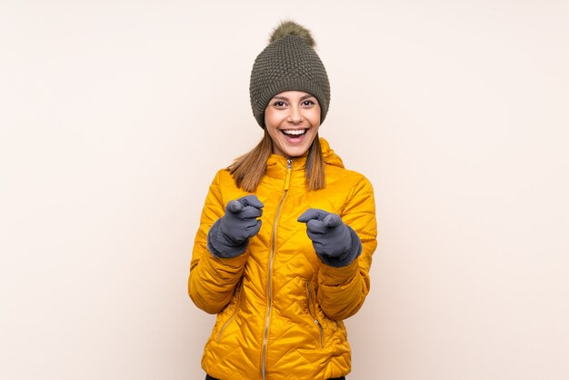 La donna con il cappello dell'inverno sopra la parete indica il dito