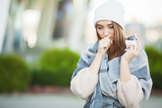 La donna con influenza all'aperto si è vestita in protezione