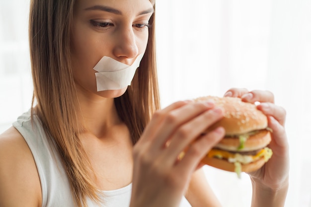 La donna con la bocca bloccata cerca di mangiare cibo cattivo