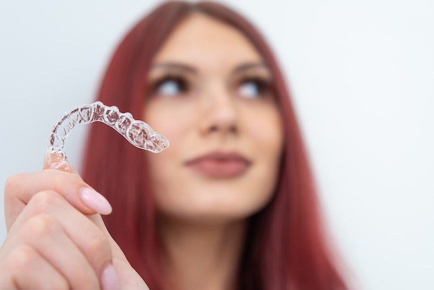 La donna con un bel sorriso mostra un paradenti trasparente