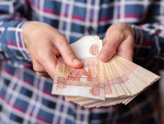 La donna conta i soldi le mani femminili tengono le denominazioni delle banconote in contanti di 5000 rubli di valuta