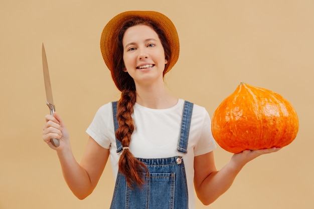 La donna contadina si prepara a tagliare una lanterna con un coltello da una zucca matura per halloween