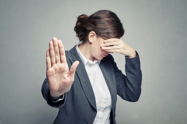 La donna copre il viso e mostra il gesto di stop